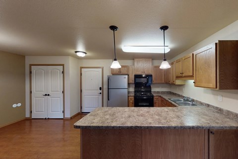 A kitchen with a granite countertop and wooden cabinets.