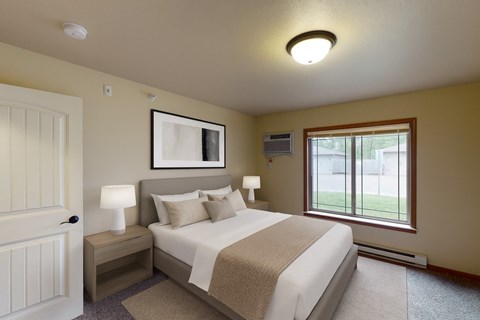 A bedroom with a large bed and a window.