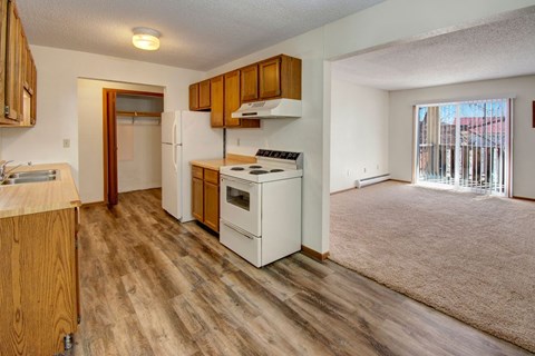 A kitchen with wooden cabinets and a white stove top oven.