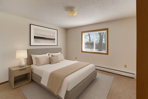 A bedroom with a large bed and a nightstand with a lamp.