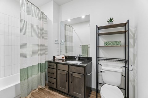 A bathroom with a white toilet and a wooden cabinet.