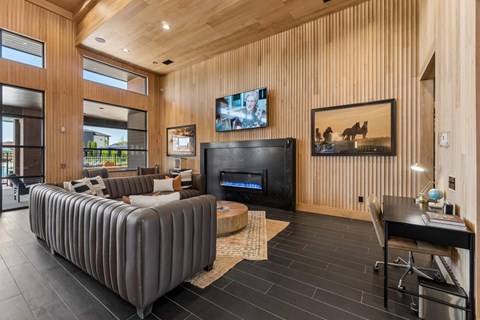 A modern living room with a grey sofa and a wooden wall.