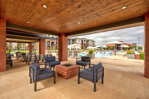 A wooden covered patio with blue cushioned seating.