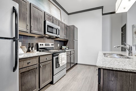 A kitchen with dark wood cabinets and stainless steel appliances.