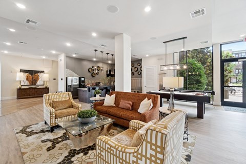 A living room with a pool table and a view of the city.
