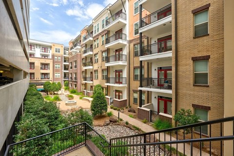 A view of a courtyard from a balcony of a building.
