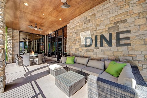 A dining area with a stone wall and a sign that says "DINE".