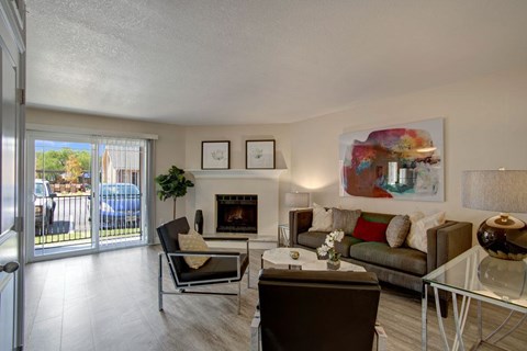 A living room with a fireplace, couch, and chairs.