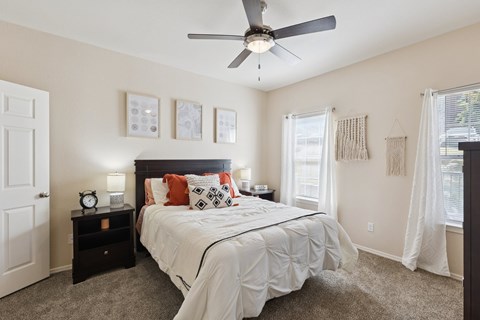 A bedroom with a large bed and a ceiling fan.