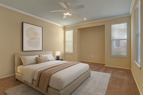 A bedroom with a large bed and a ceiling fan.