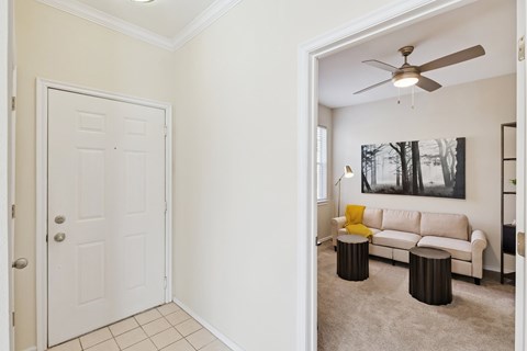 A living room with a white couch and a ceiling fan.