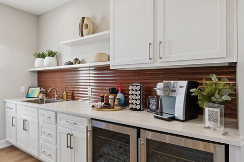 A kitchen with white cabinets and a brick backsplash.