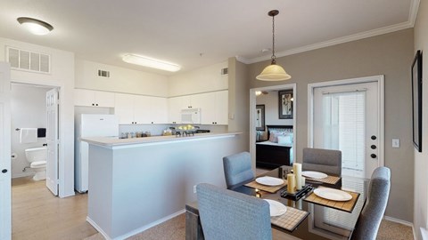 A modern kitchen with a dining table set for two.