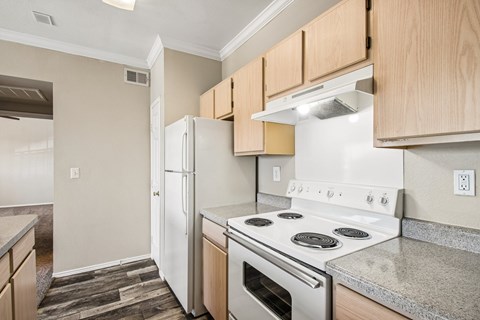 A kitchen with a white stove top oven and white refrigerator.