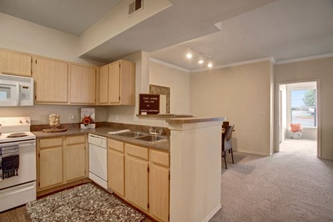 A kitchen with wooden cabinets and a white stove.