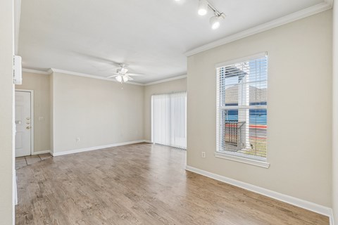 A spacious room with a window overlooking a pool.