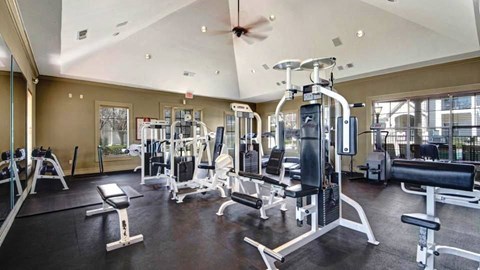 A spacious gym with a variety of equipment including treadmills, weight machines, and benches.