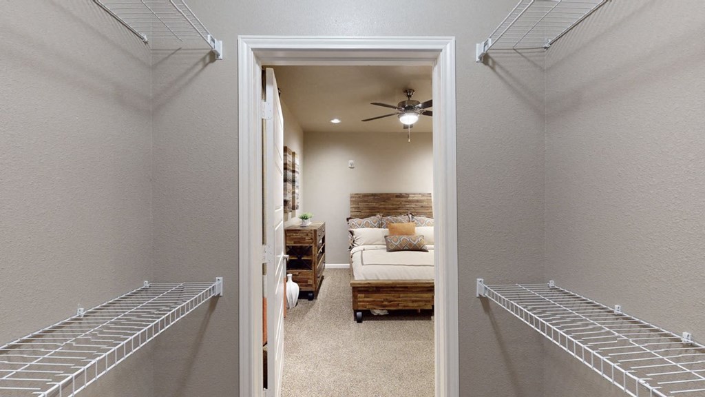 a bedroom with a ceiling fan and two walk in closets