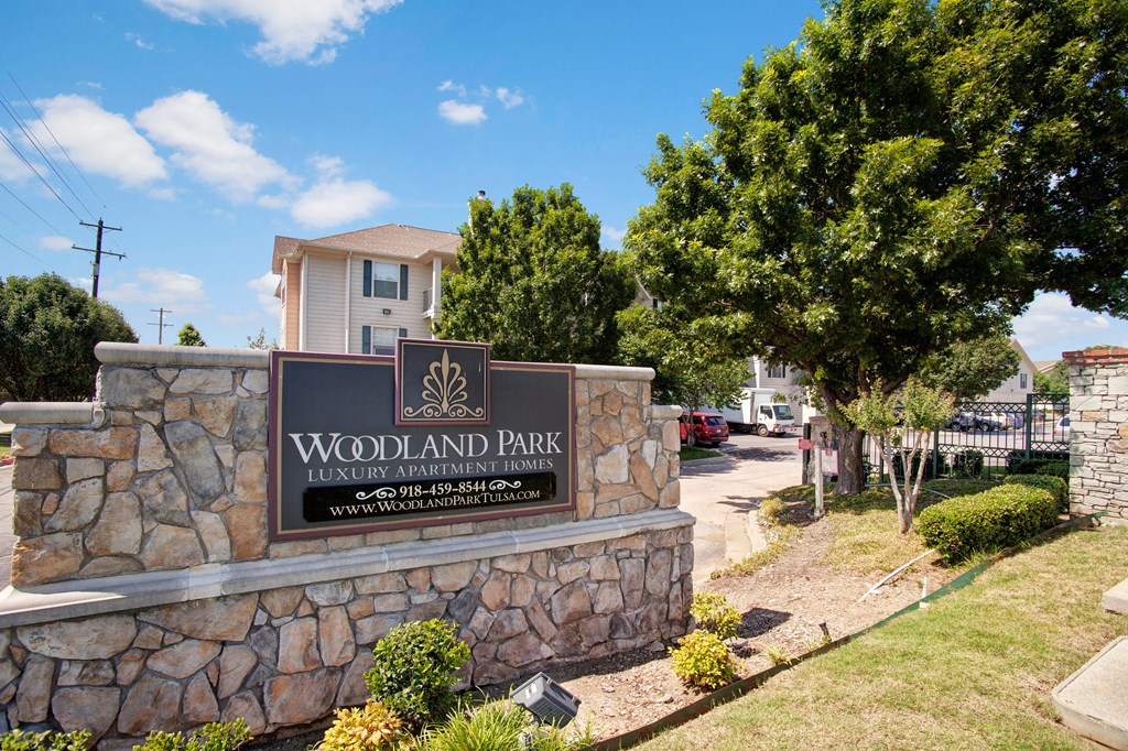 the sign at the entrance of woodlands park apartments