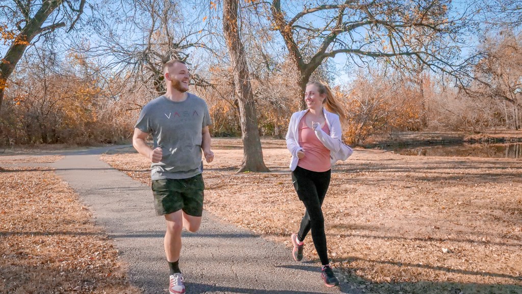 A man and a woman running down a road at Legends of River Oaks