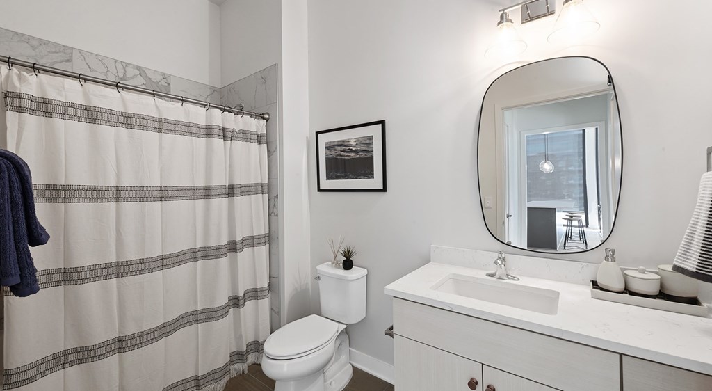A bathroom with a toilet, sink, and shower curtain.