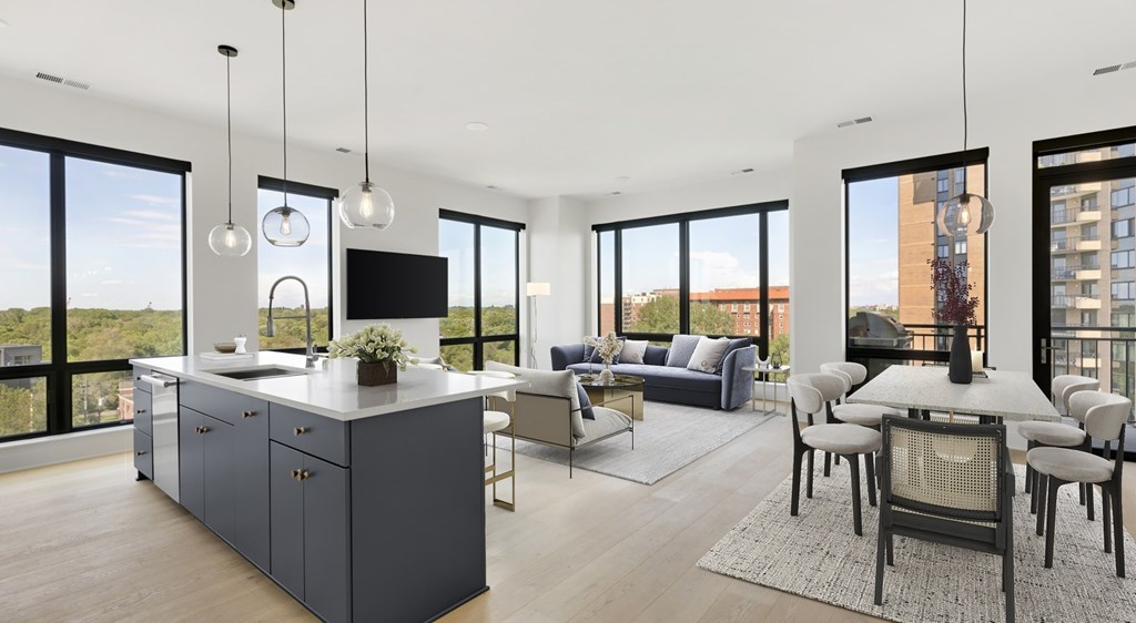 A modern kitchen with a large island and a dining table with chairs.