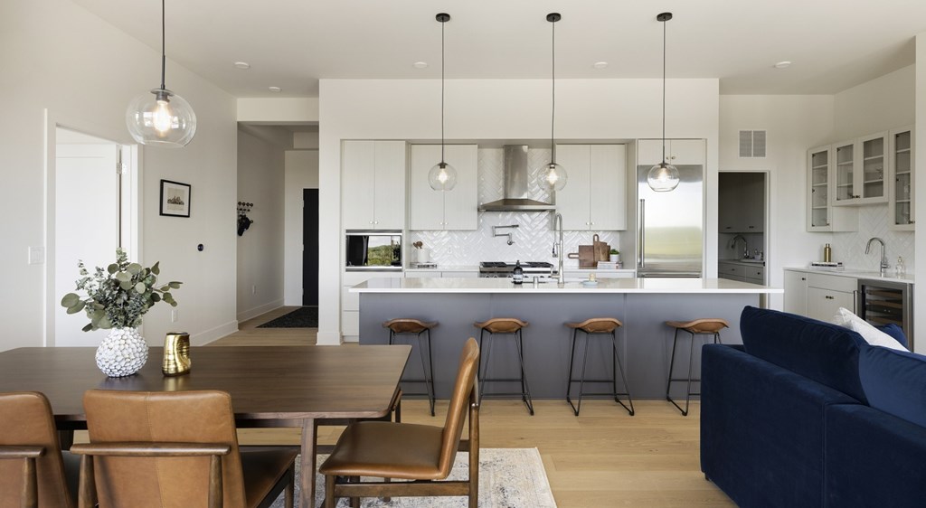A modern kitchen with a dining table and chairs.