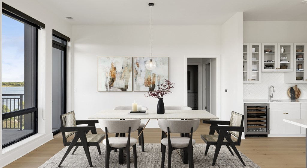 A modern dining room with a white table and chairs.