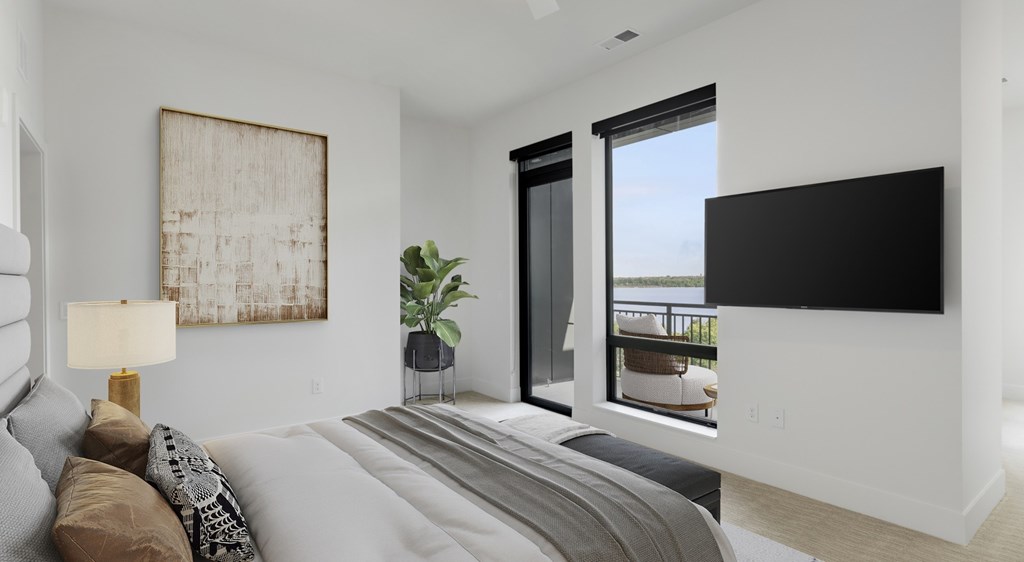 A modern bedroom with a large bed and a flat screen TV mounted on the wall.