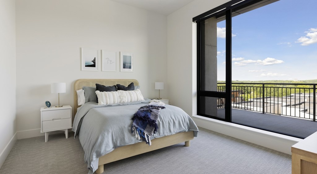 A bedroom with a large bed and a view of the outside.