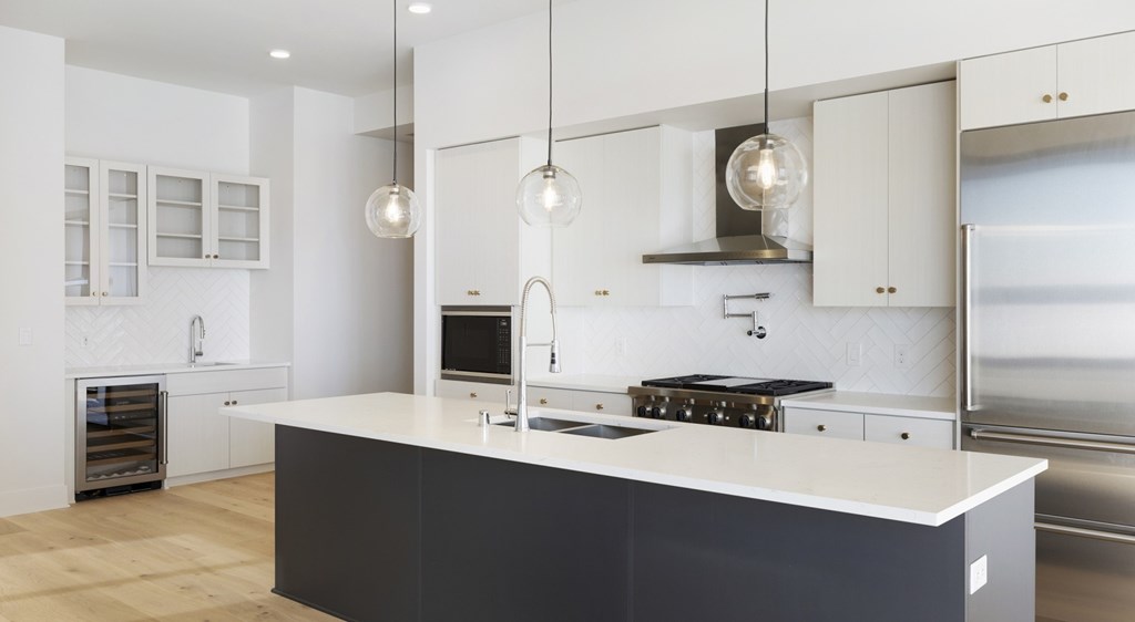 A modern kitchen with a large island and stainless steel appliances.