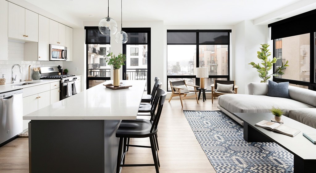 A modern kitchen with a large island and a view of the city.
