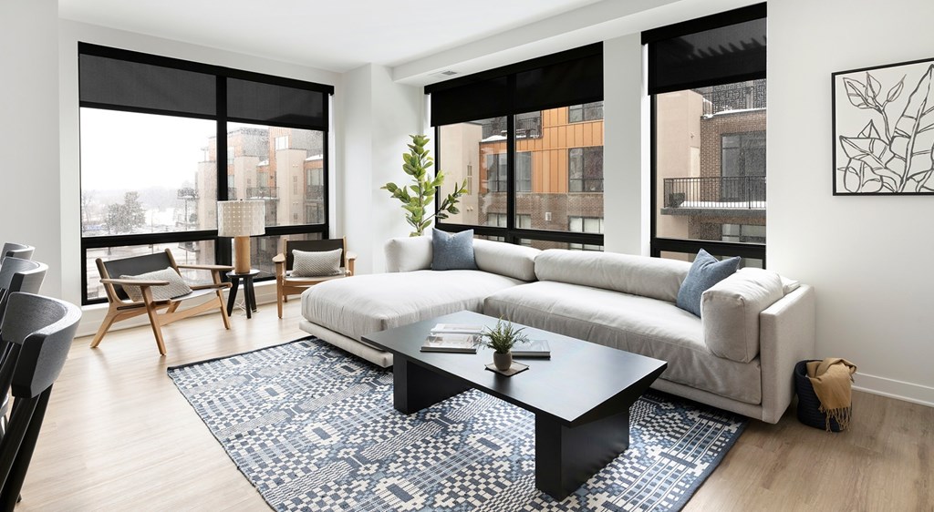 A living room with a white couch and a black coffee table.