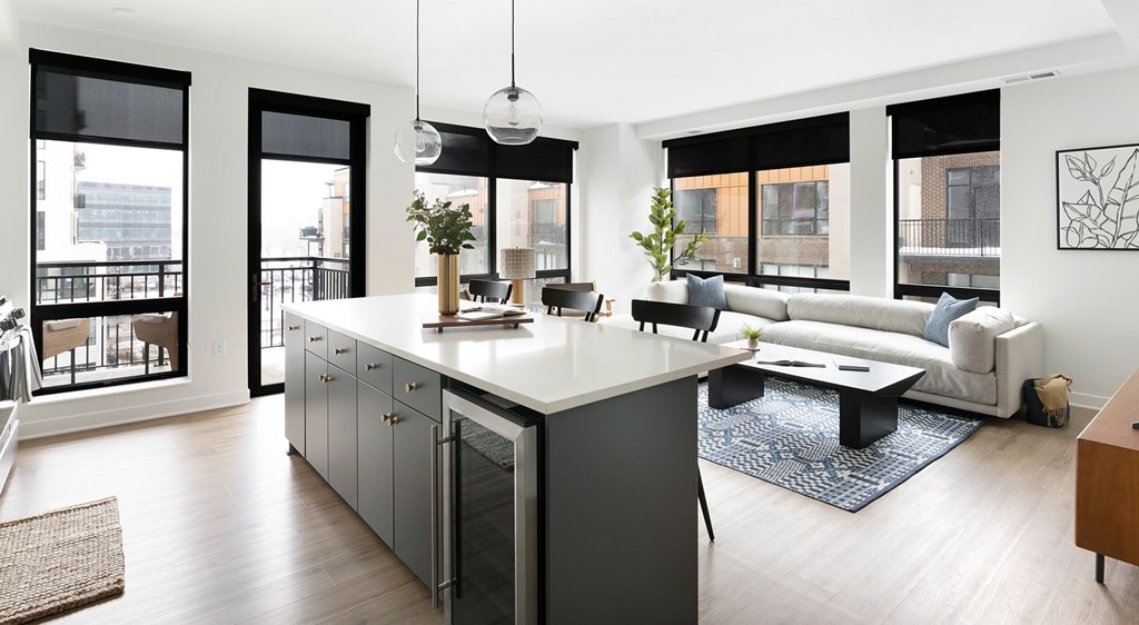 A modern kitchen with a large island and a view of the city.