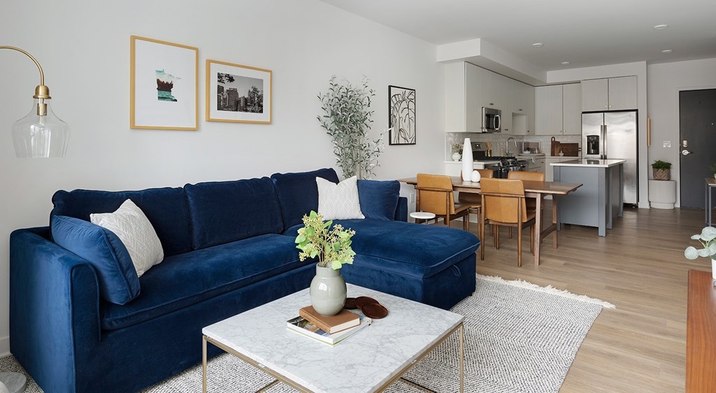 A blue couch sits in a living room with a coffee table in front of it.