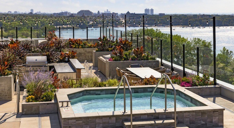 A pool surrounded by a patio with a laptop on it.