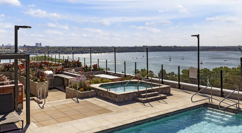 A pool with a view of the water and a city skyline.