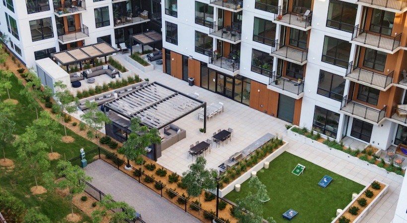 A modern apartment complex with a courtyard and a playground.