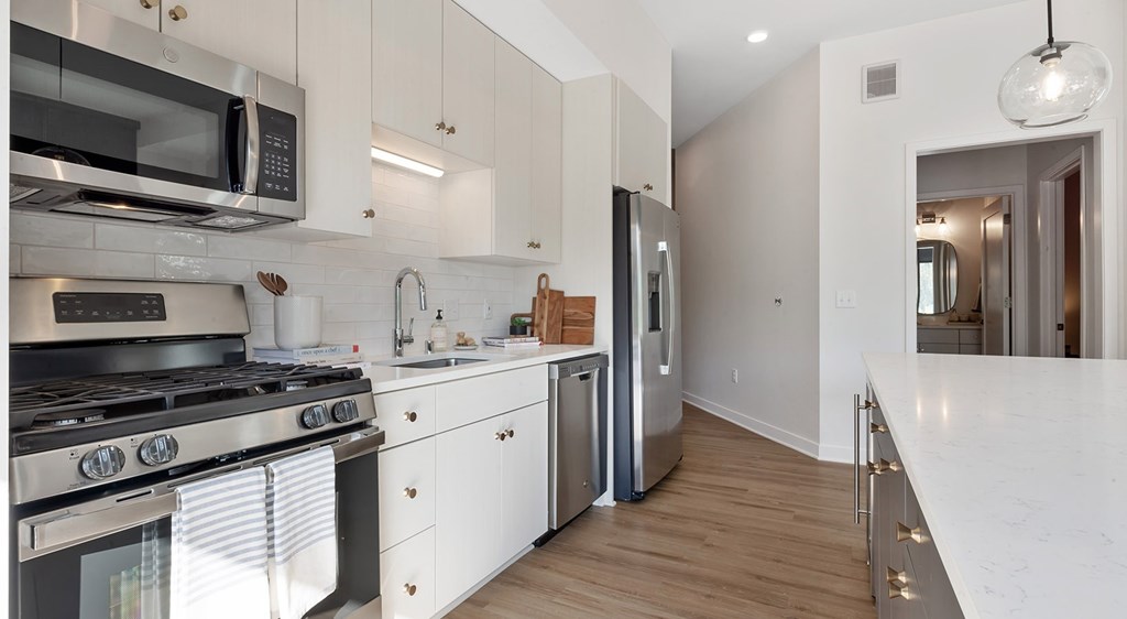 A modern kitchen with white cabinets and stainless steel appliances.