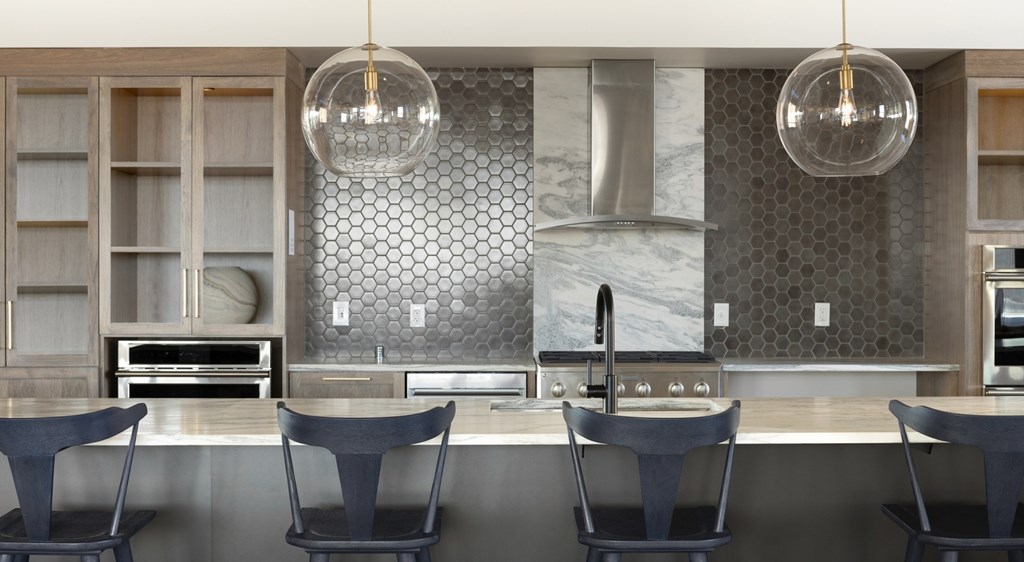 A modern kitchen with a marble backsplash and a central island.