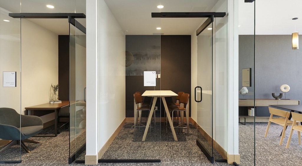 A modern room with a glass wall and a table with chairs.