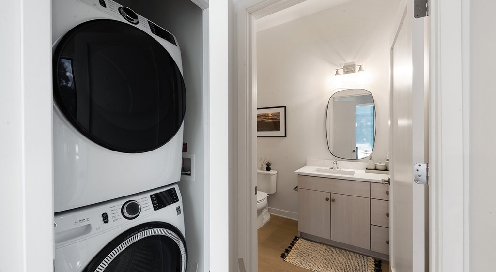 A white washing machine is in a small laundry room.