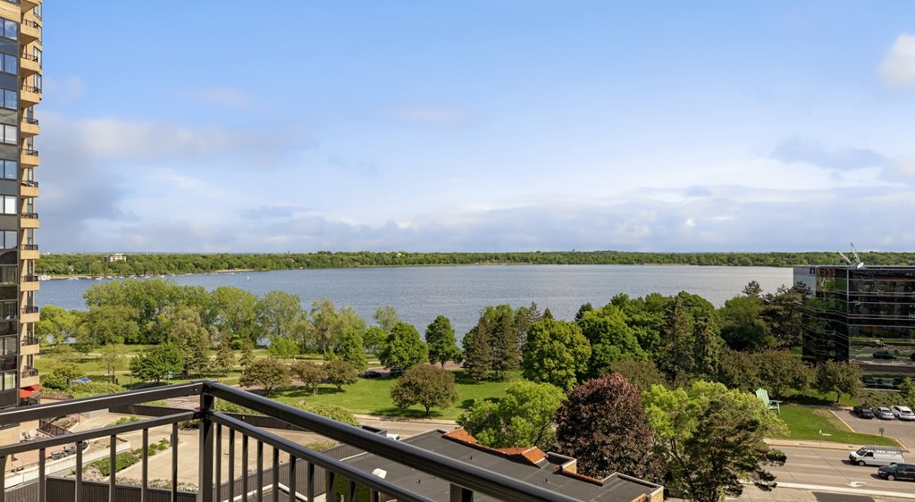 A view from a balcony overlooking a lake and a cityscape.