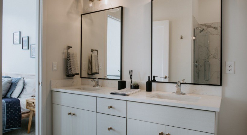A bathroom with a white vanity and a large mirror.