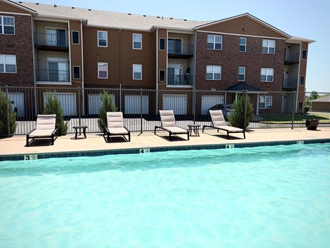 A large apartment complex with a pool in front.
