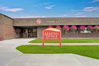 a leasing office sign in front of a brick building
