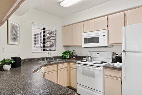 A kitchen with a white stove top oven and white refrigerator.