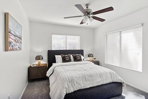 A bedroom with a large bed and a ceiling fan.