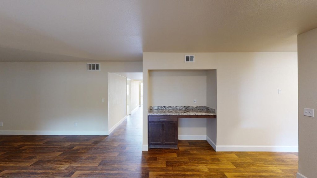 an empty living room with white walls and wooden floors