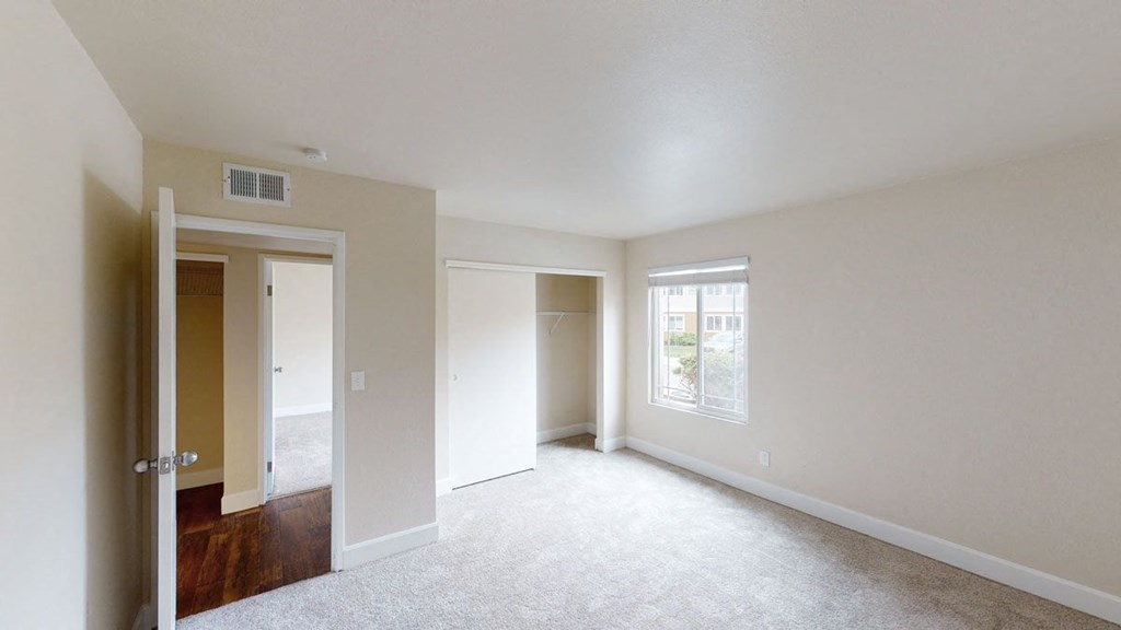 a bedroom with white carpet and white walls